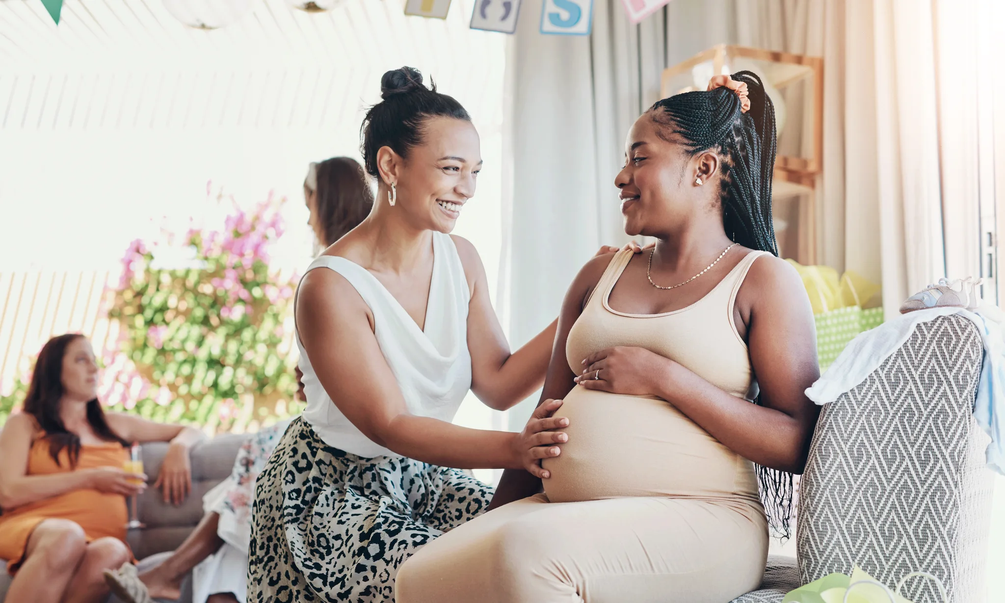 a pregnant woman by a window at sunset
